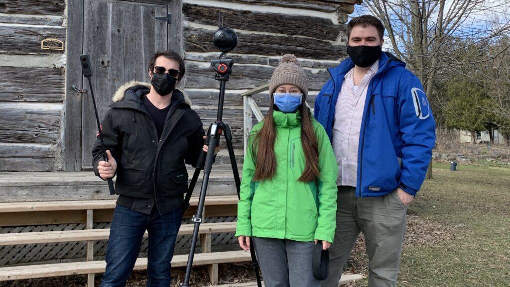 Dave, Luna and Andre of Ballinran Entertainment stand in front of a log building with 8K camera equipment used in VR video production