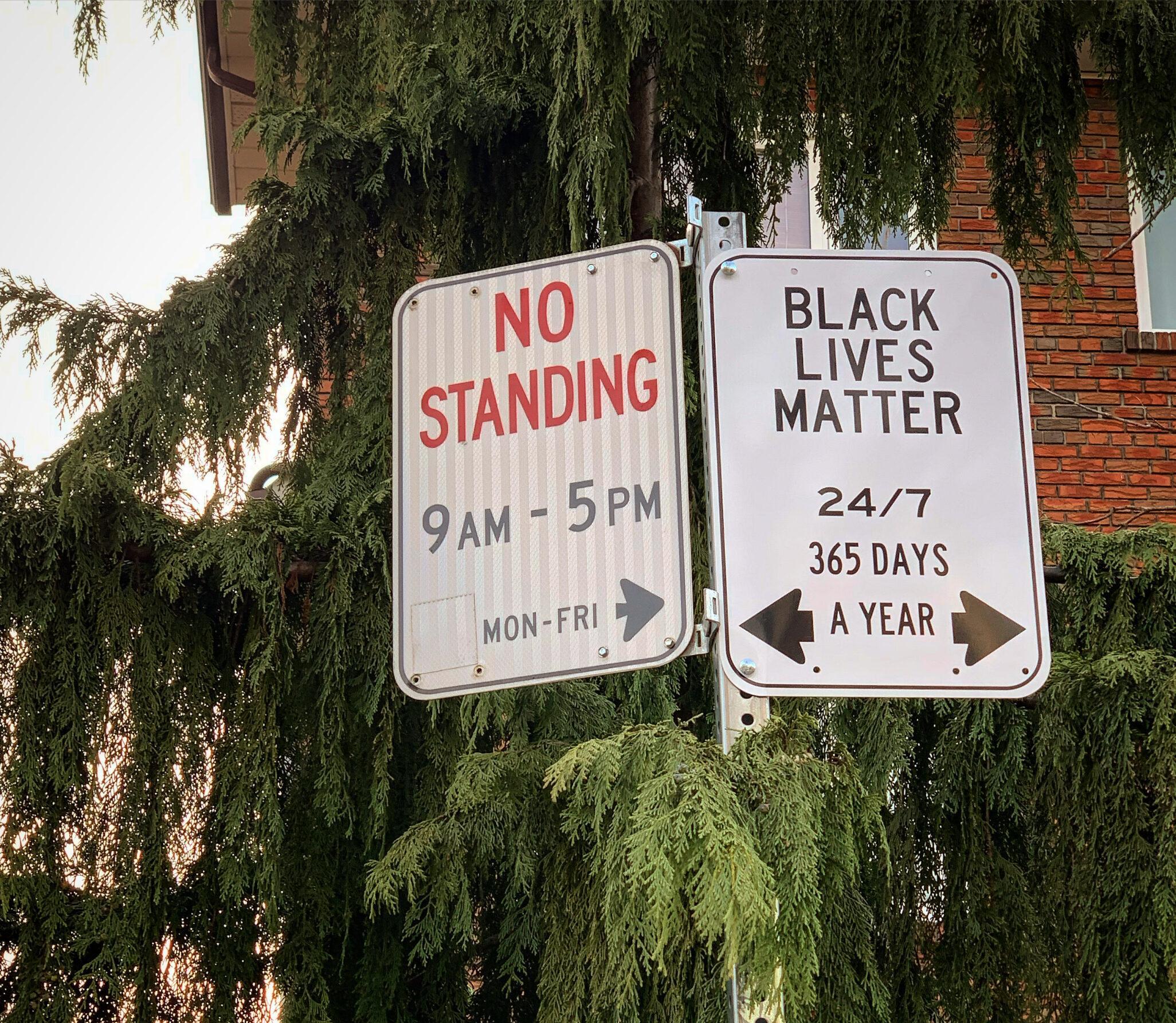 Black Lives Matter sign beside a typical "No Standing" traffic sign.