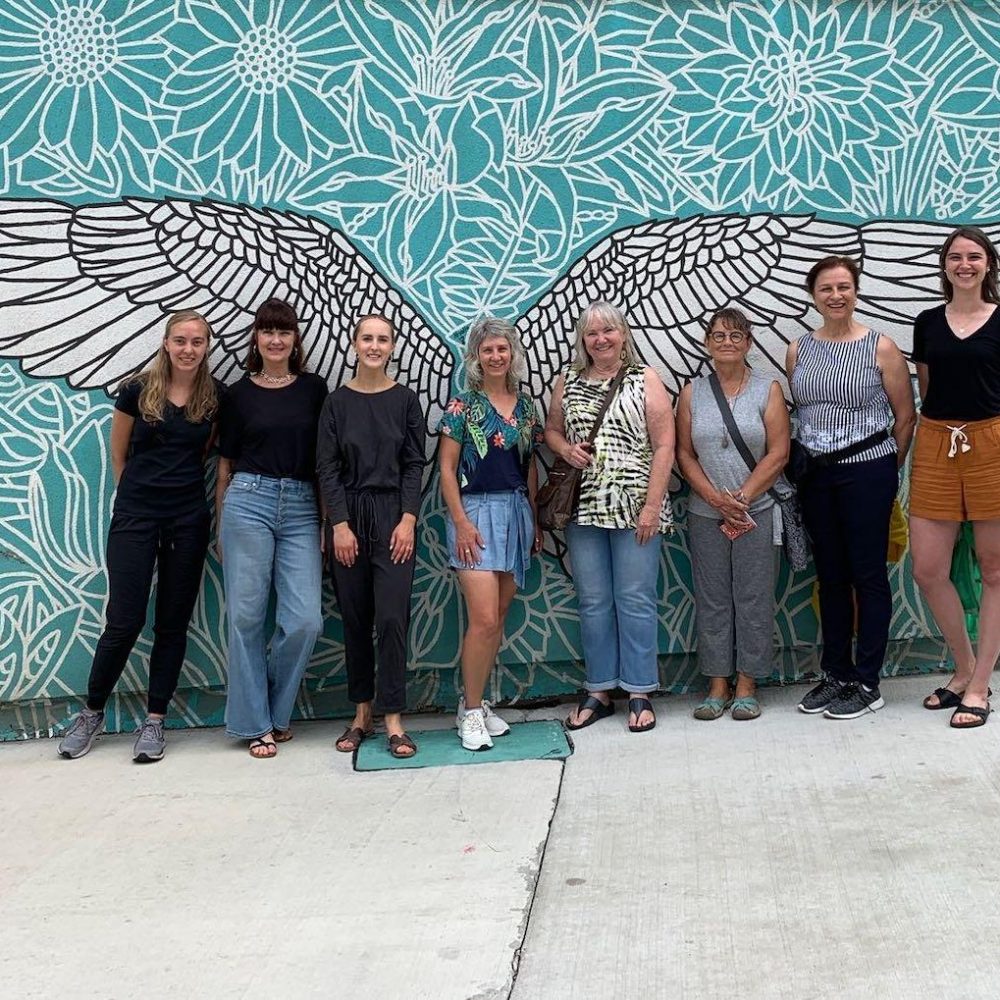 a walking tour group standing in front of the Galt Winds Mural in Cambridge Ontario